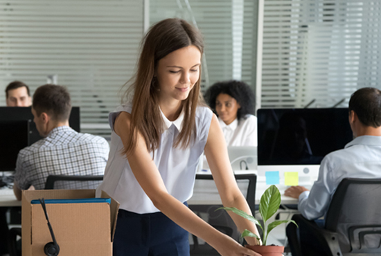A young woman setting up her desk on her first day of work